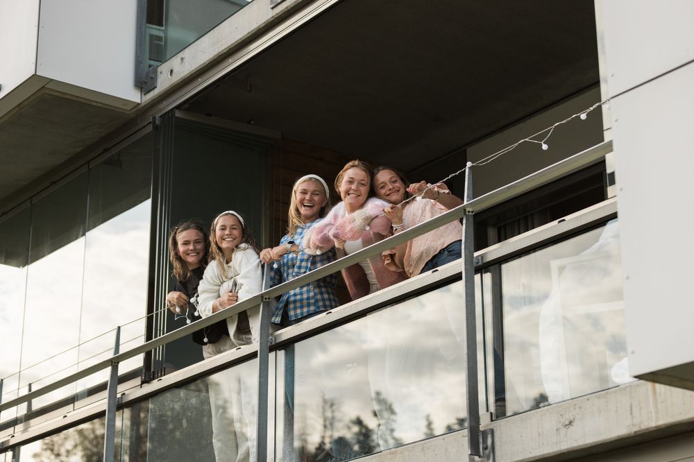 Unge voksne som henger lyslenke på balkongen