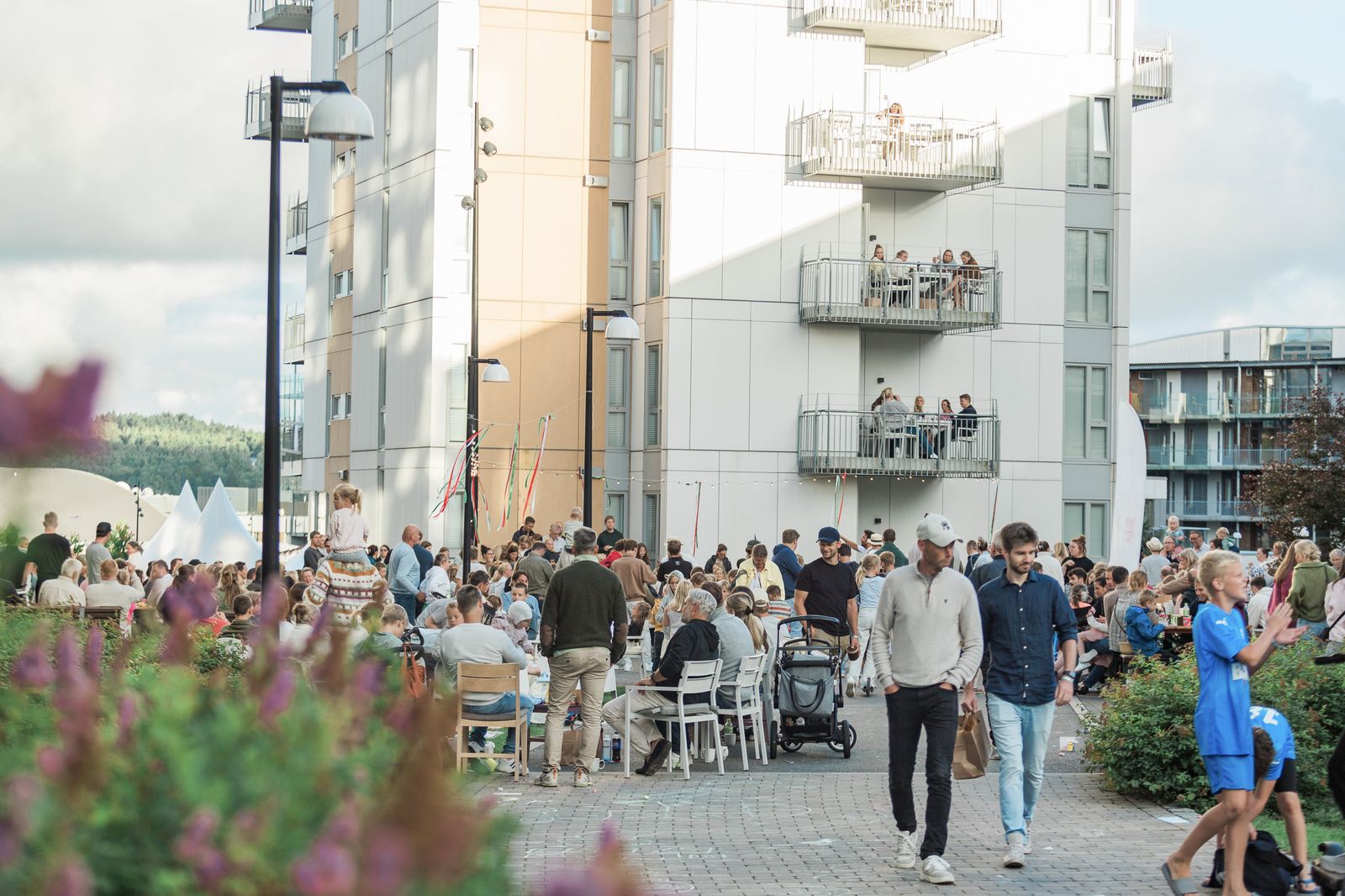 Fellesskap på Brunstad — mennesker samlet til grendefest med balkonger over